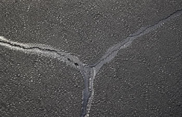 Asphalt crack repair closeup with sealed cracks