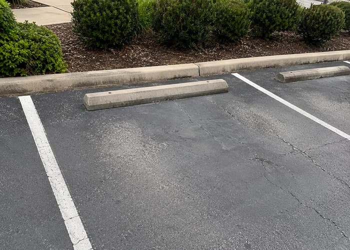 Customer-style parking space photo with curb and centered wheel stop