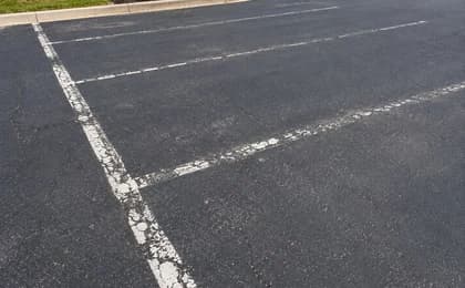Close customer-style photo of faded white parking lot lines